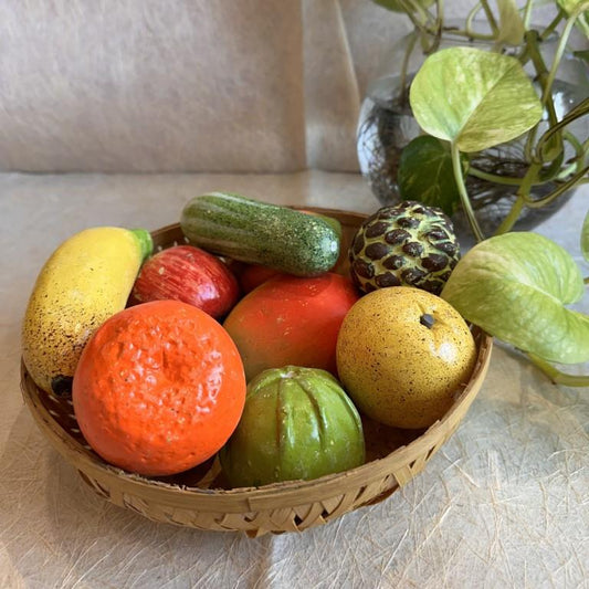 Handwoven basket with vibrant handcrafted fruit props, including banana, orange, apple, guava, and more, for Navarathri Golu decoration.