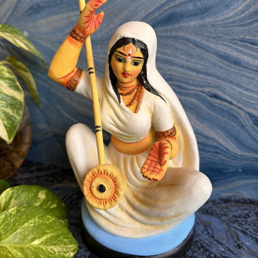 Close-up of a handcrafted Navarathri Golu doll depicting Saint Mirabai holding an ektara, dressed in a white saree with detailed hand-painted accents.