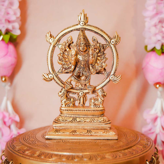 Chakrathalwar brass idol of Lord Vishnu with Sudarshana Chakra, displayed with floral decorations, showcasing intricate craftsmanship.