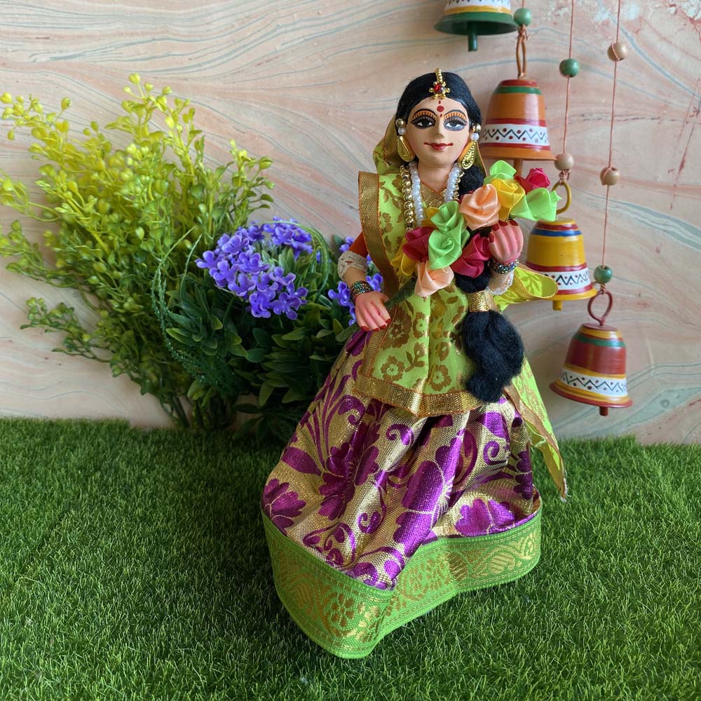 Handcrafted Navarathri costume doll of a girl holding a colorful flower bouquet, dressed in vibrant traditional attire with intricate details.