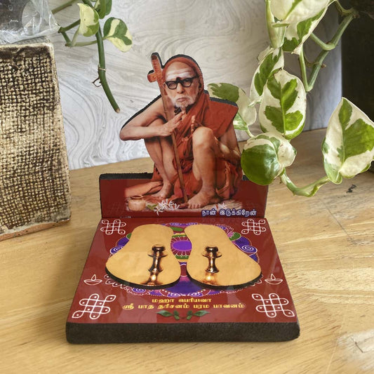 Mahaperiyava Patham L-Shape Photo Stand featuring a divine image of the sage and symbolic padukas on a decorative base.