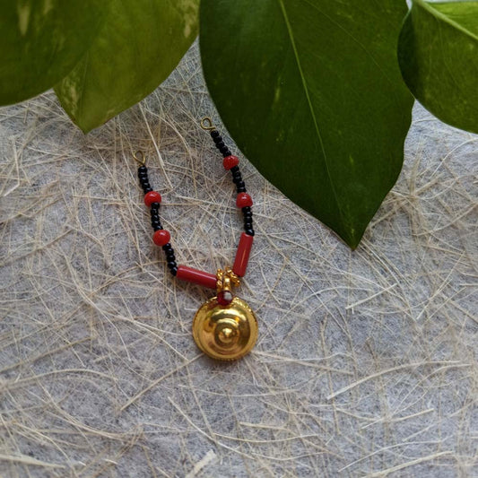 Traditional Thali pendant with black and red beads featuring a golden centerpiece for cultural and religious ceremonies.