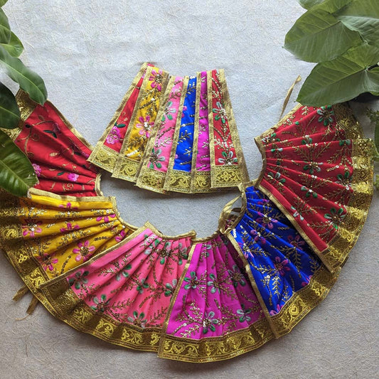 Vibrant and colorful floral Devi skirts with intricate gold embroidery and embellishments, arranged beautifully in a circular pattern.