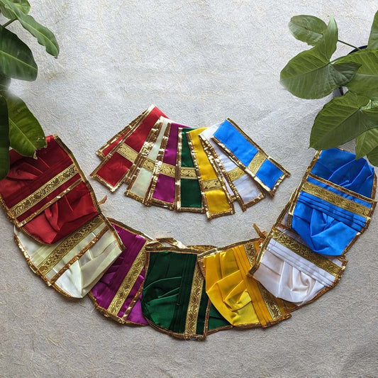 A set of multicolored traditional Panchakacham fabric wraps with intricate golden zari borders, neatly displayed on a textured background with green leaves.