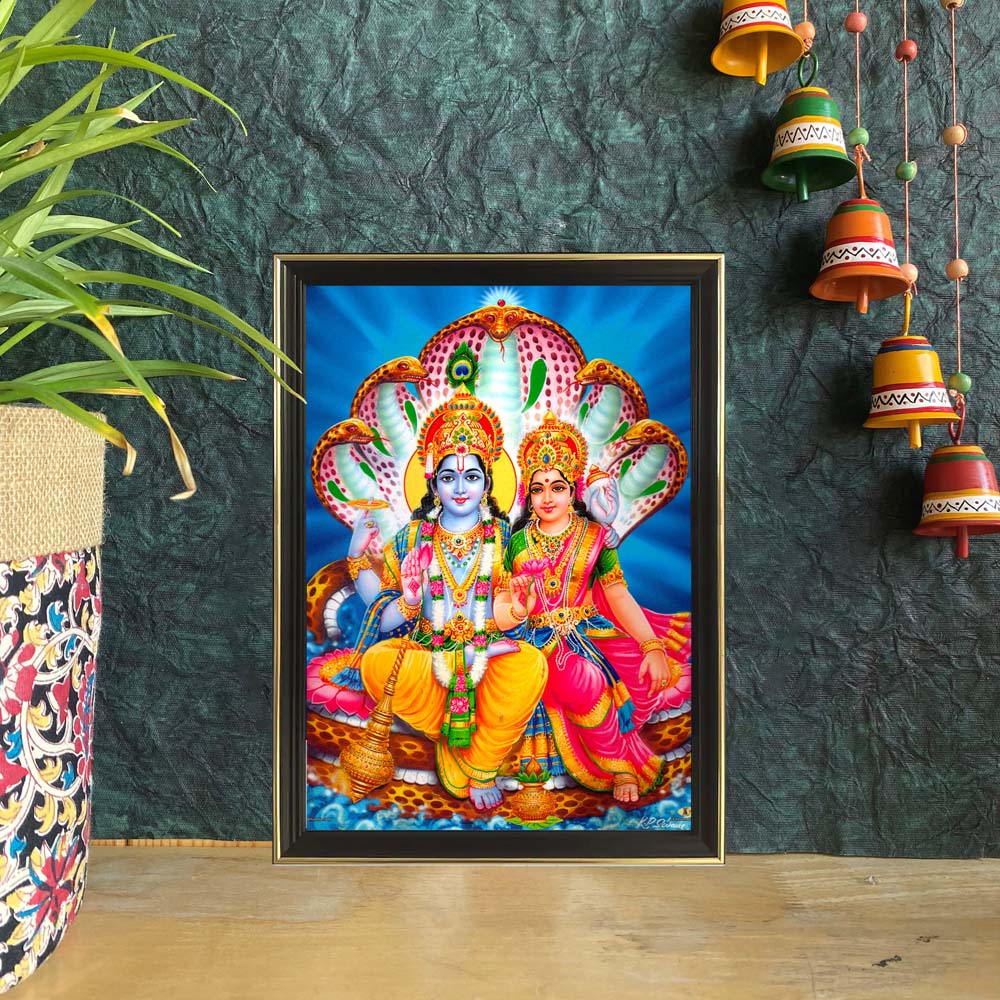 Framed artwork of Lord Vishnu and Goddess Lakshmi seated on Shesha Naaga with a serene blue background.