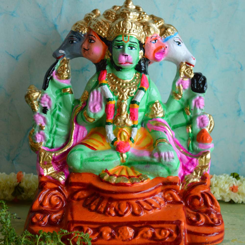 Handcrafted Panchamukha Hanuman idol with vibrant green, gold, and orange hues, designed for Navarathri Golu displays, placed against a light blue background.